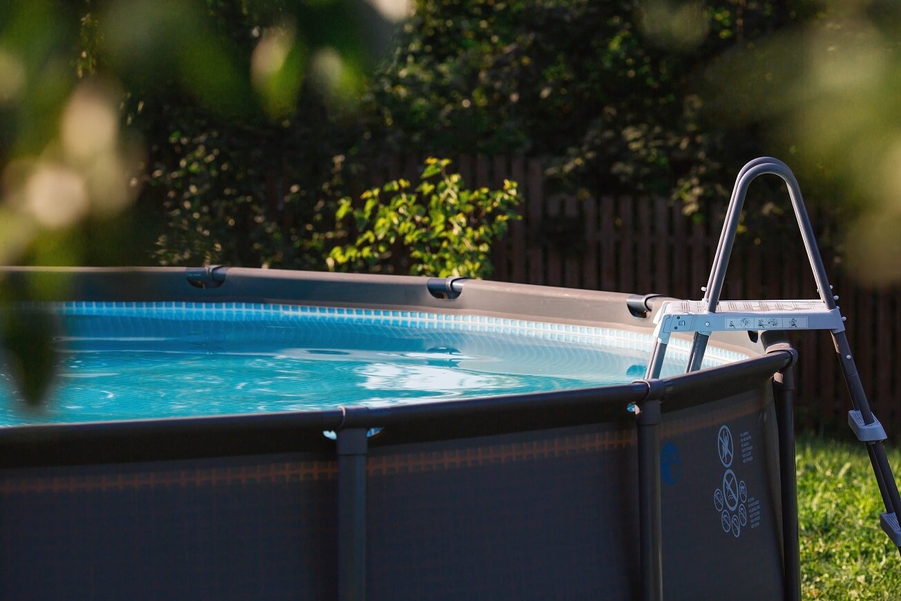 Freistehender Pool für den Sommer im heimischen Garten | © stock.adobe.com Runder Aufstellpool im Garten mit Leiter | © stock.adobe.com