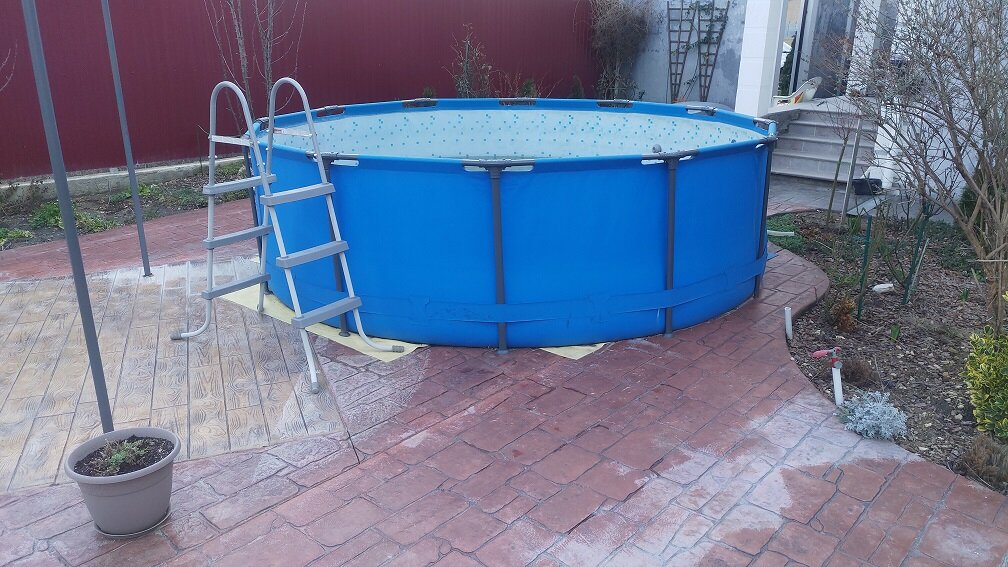 Kompakter Aufstellpool für kleine Flächen oder Terrassen | © stock.adobe.com Blauer Rundpool auf gepflastertem Untergrund neben Hauswand | © stock.adobe.com