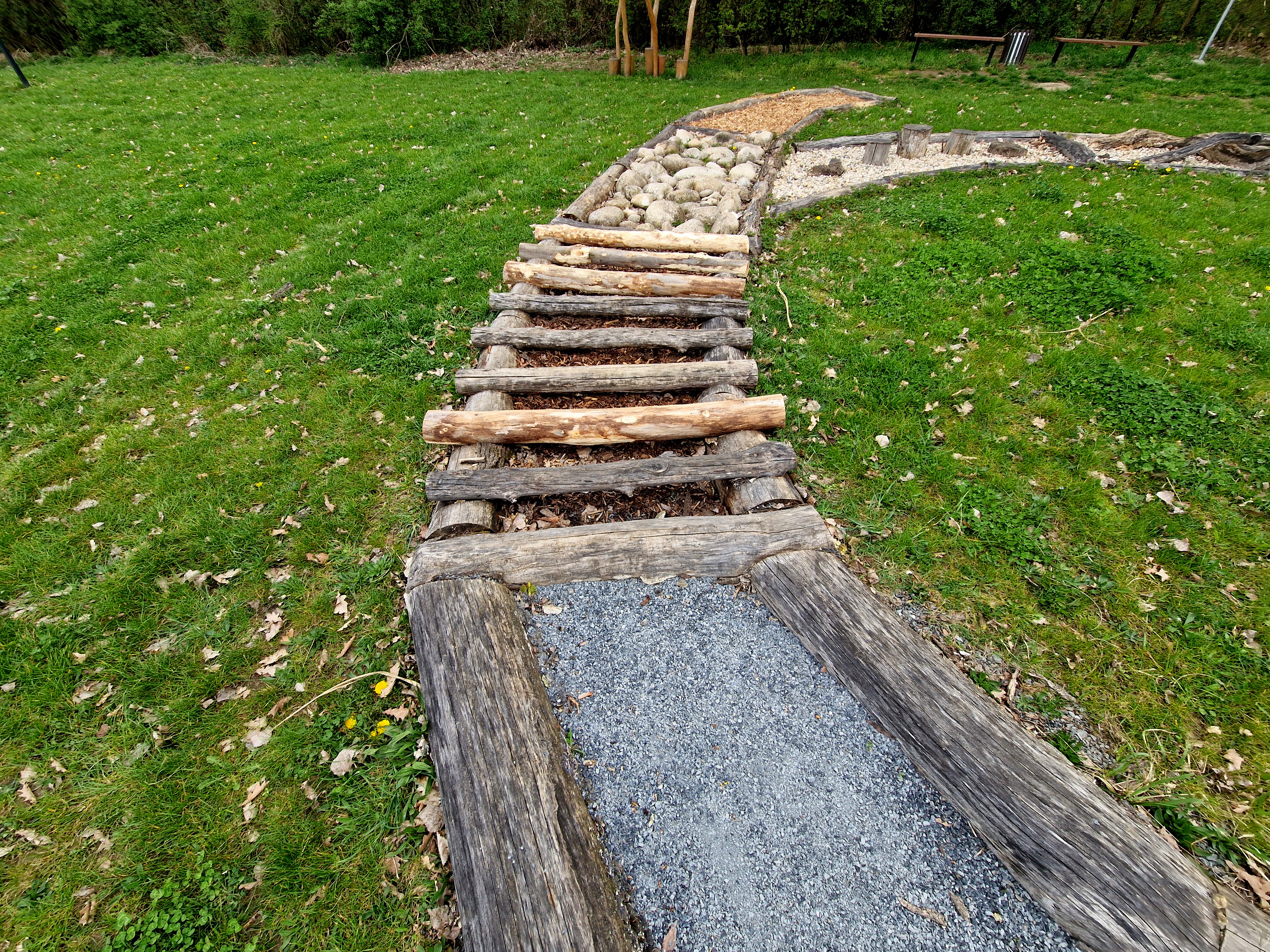 Barfuß-Erlebnisweg für Entspannung und Gesundheit im Grünen | © stock.adobe.com Langer Barfußpfad mit Holzstufen durch eine Wiese | © stock.adobe.com