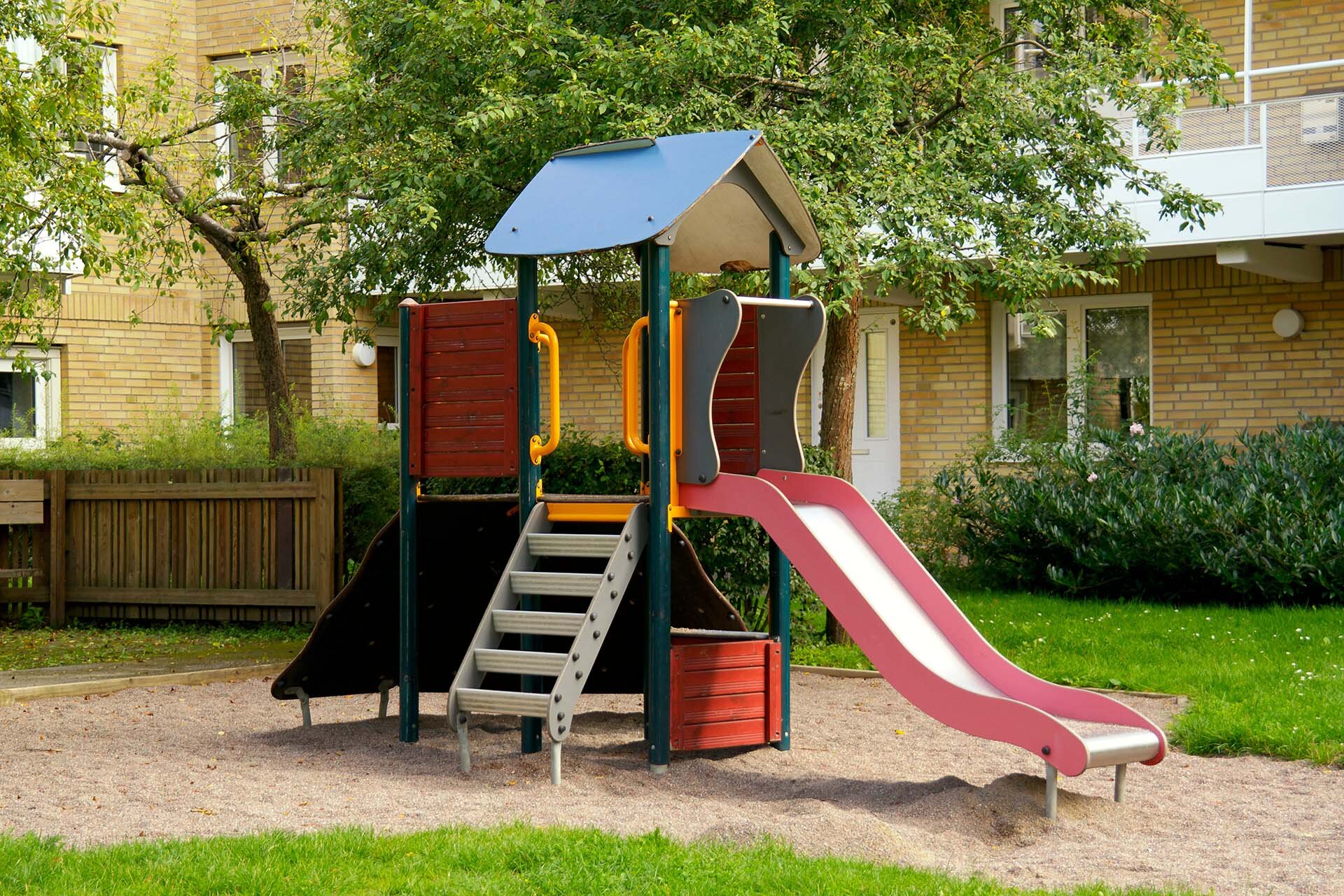 Kindgerechter Spielplatz mit Fallschutzfläche für sicheres Spielen | © stock.adobe.com Spielgerät mit Rutsche und Gummigranulat-Bodenbelag im Park | © stock.adobe.com
