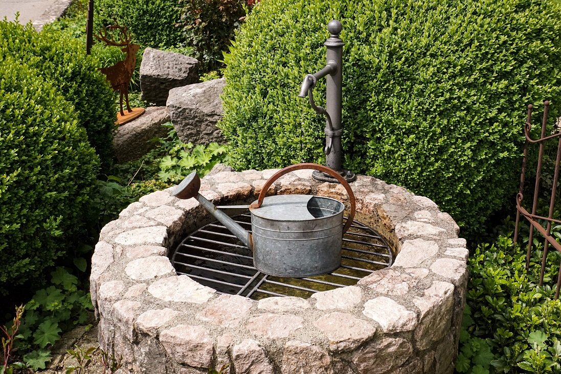Zierbrunnen mit ruhigem Wasserbild im Vorgarten | © stock.adobe.com Runder Gartenbrunnen aus Naturstein mit Wasserlauf | © stock.adobe.com