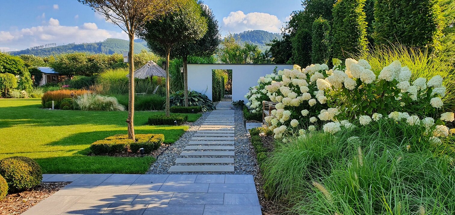 Moderner Vorgarten mit geradlinigem Wegdesign | © stock.adobe.com Gartenweg aus Steinplatten mit Blumenbeeten an den Seiten | © stock.adobe.com