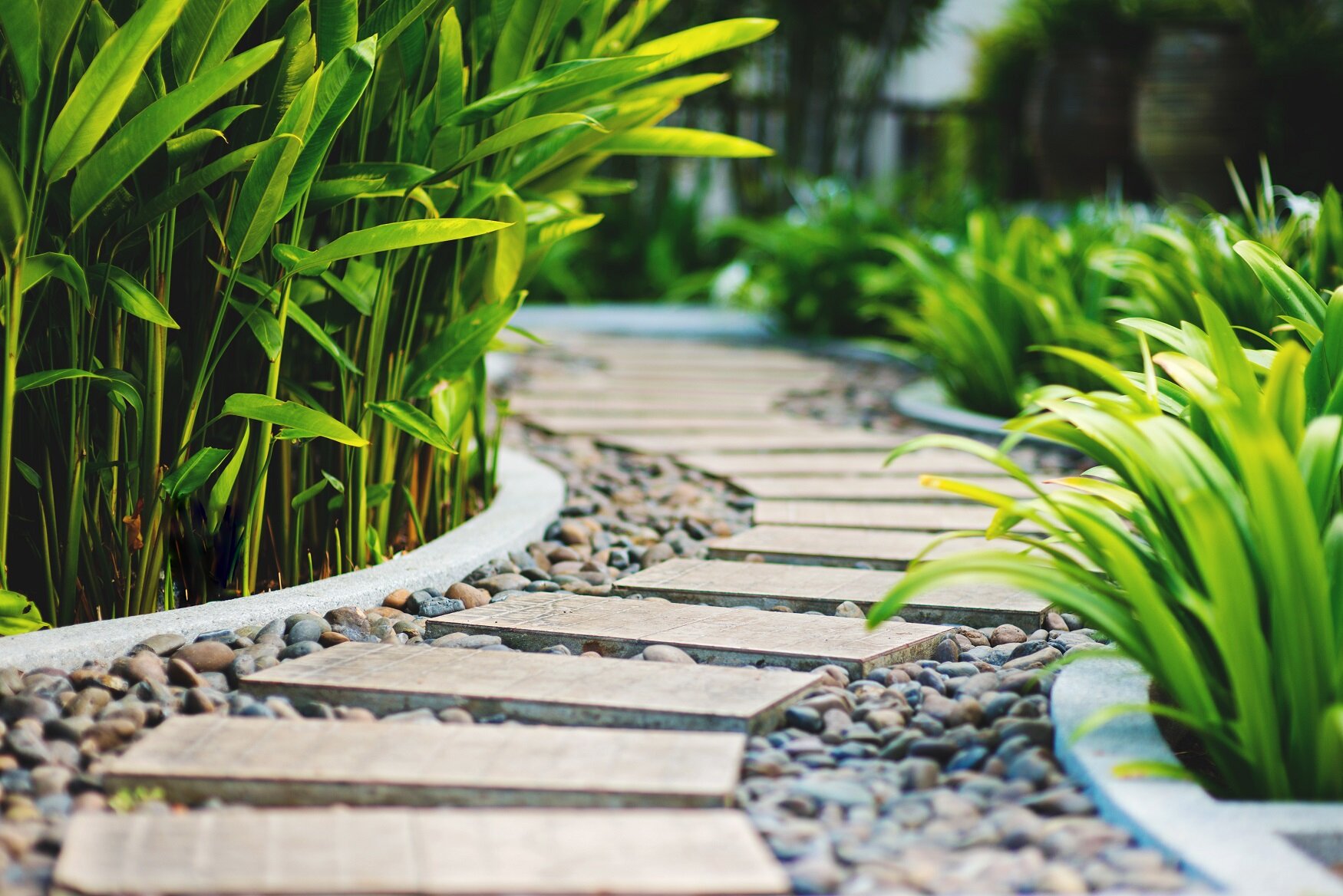 Elegante und funktionale Wegführung durch den Garten | © stock.adobe.com Gerader Gartenweg mit Trittplatten in gepflegtem Beet | © stock.adobe.com