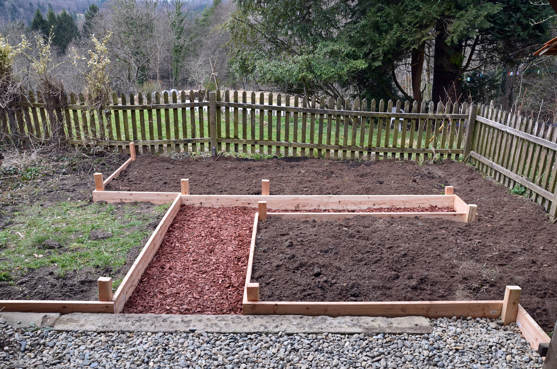Gartenweg mit Rindenmulch und Kies neben einem Holzzaun | © stock.adobe.com