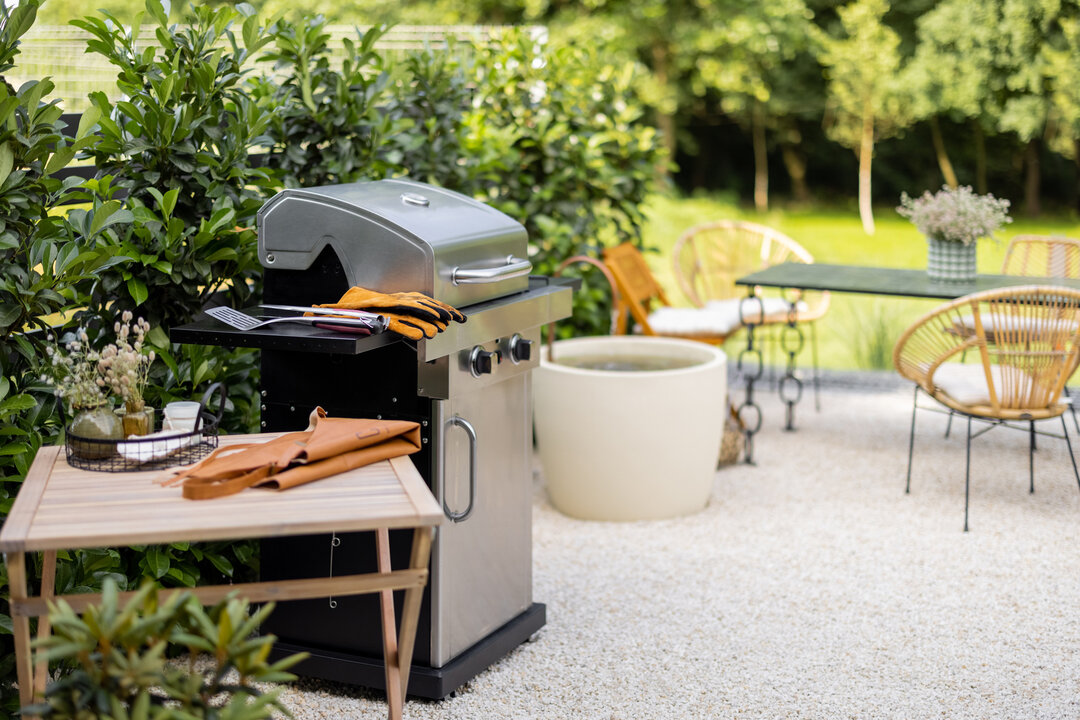 Gasgrill auf Terrasse mit Esstisch und Pflanzen im Hintergrund | © stock.adobe.com