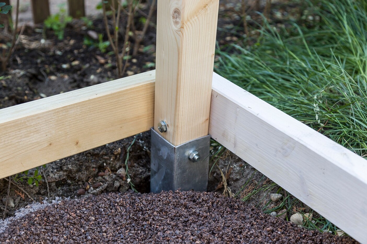 Stabile Unterkonstruktion für Terrassen oder Hochbeete | © stock.adobe.com Eingelassene Pfostenträger mit Holzrahmen auf Splittfläche | © stock.adobe.com