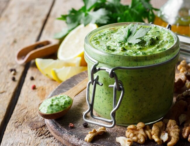 Hausgemachter Kräuterdip mit Petersilie und Nüssen | © stock.adobe.com Frisches Petersilienpesto mit Zutaten und Löffel | © stock.adobe.com